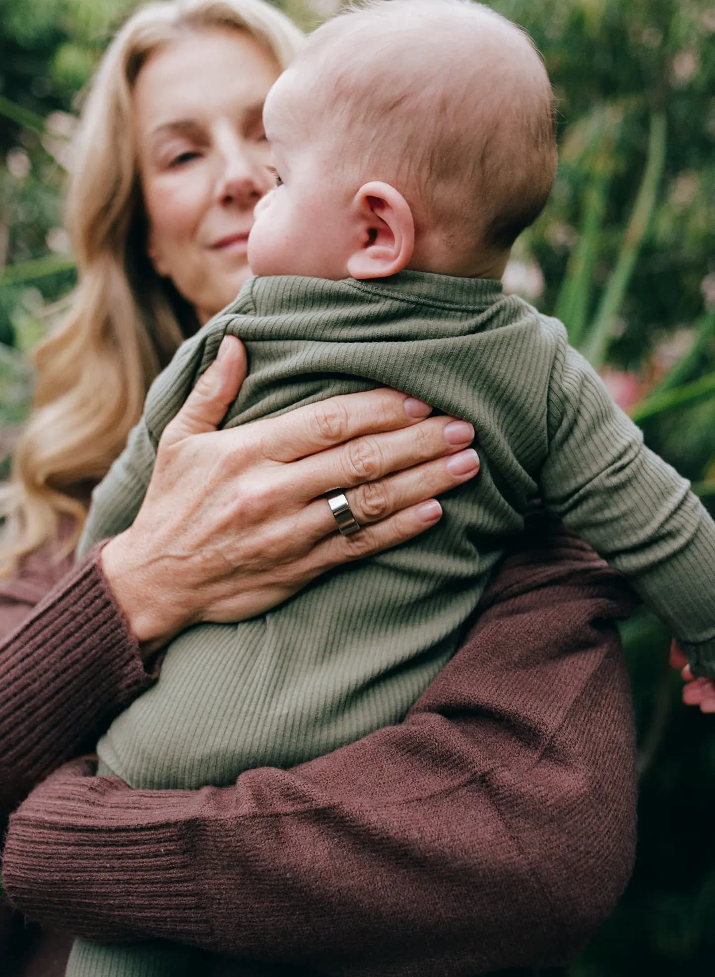 Woman with an AlterMe ring on her right hand holding a baby